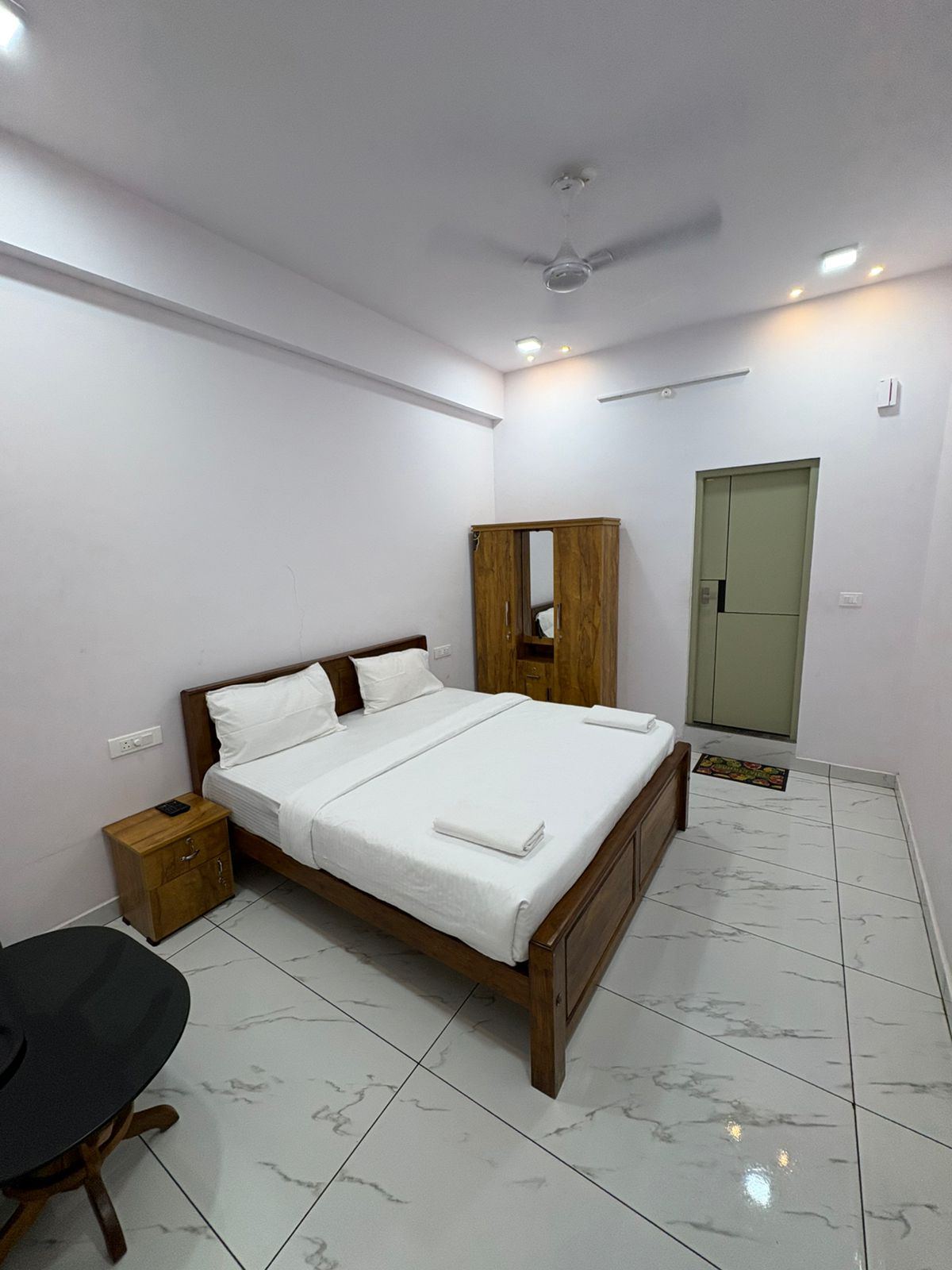 Deluxe room with a wooden double bed, wardrobe and marble flooring