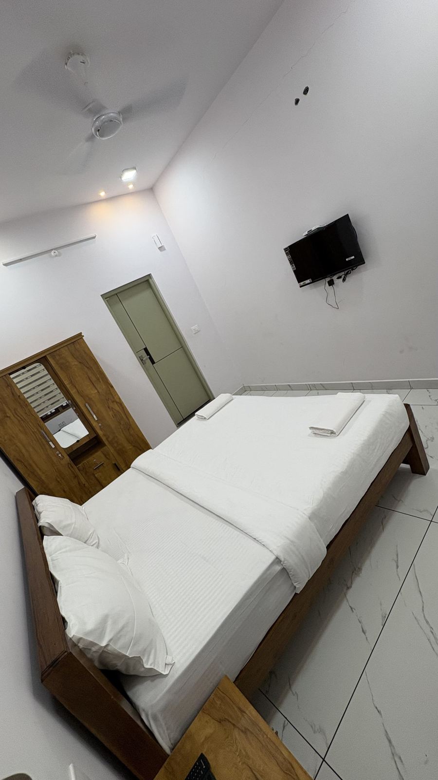 Deluxe Room bed and wall-mounted TV